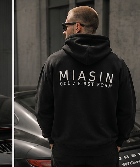 A model photographed from behind wearing the black MIASIN 001 hoodie