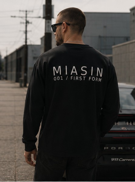 A model photographed from behind wearing the black MIASIN 001 long sleeve