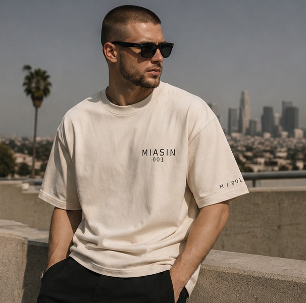 A model wearing the MIASIN 001 Box Tee in bone against the Los Angeles skyline