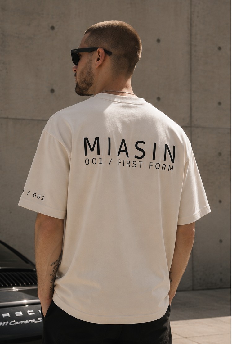 A model wearing the MIASIN 001 Box Tee in bone, back view